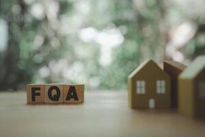 Wooden blocks with the word FAQ with wood home blur a foreground frequently asked questions. photo