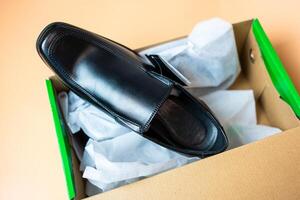 Modern black leather shoes for male in shoe box photo