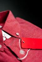 Detail of a folded male red shirt with red label photo