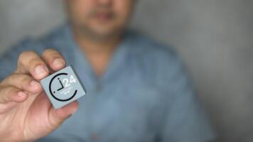 Technician man show wood block with an icon of nonstop service. Technical support customer. photo