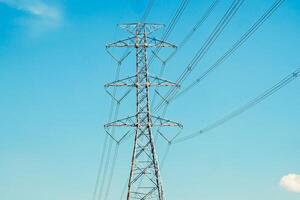 High Voltage Power Line Tower Against Clear Blue Sky - Energy Infrastructure and Electricity Transmission Concept photo