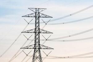 High Voltage Power Line Tower Against a Clear Sky at Dusk - Industrial Infrastructure and Energy Transmission Concept photo