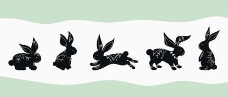 Set of rabbit silhouettes in different poses. Hand drawn rabbits decorated with white ornament with botanical elements. Animals drawing in boho style. illustration vector
