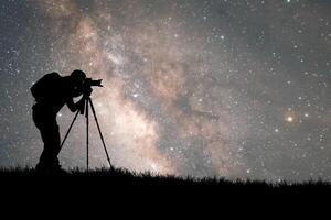Silhouette of a Photographer Capturing the Night Sky with the Milky Way in the Background photo