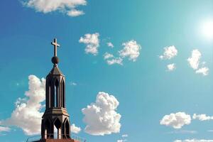 Iglesia campanario en contra un brillante azul cielo con mullido blanco nubes y luz de sol - cautivador arquitectónico detalle de un religioso edificio en un sereno y pacífico ajuste foto