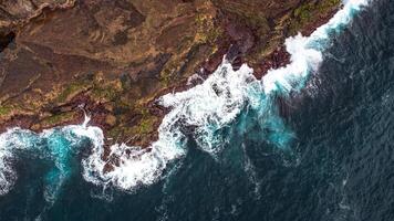Stunning drone shots of Little Blowhole, Kiama, capturing the intricate rock formations and dynamic waves from a top-down view. Perfect for showcasing Australia's coastal beauty and natural wonders. photo