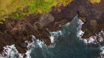 Stunning drone shots of Little Blowhole, Kiama, capturing the intricate rock formations and dynamic waves from a top-down view. Perfect for showcasing Australia's coastal beauty and natural wonders. photo