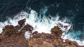 Stunning drone shots of Little Blowhole, Kiama, capturing the intricate rock formations and dynamic waves from a top-down view. Perfect for showcasing Australia's coastal beauty and natural wonders. photo