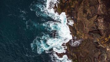 Stunning drone shots of Little Blowhole, Kiama, capturing the intricate rock formations and dynamic waves from a top-down view. Perfect for showcasing Australia's coastal beauty and natural wonders. photo