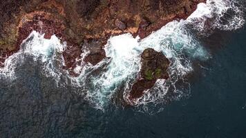 Stunning drone shots of Little Blowhole, Kiama, capturing the intricate rock formations and dynamic waves from a top-down view. Perfect for showcasing Australia's coastal beauty and natural wonders. photo