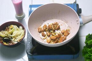 the activity of eating chicken being roasted in a pan photo