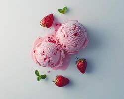 two scoops of ice cream with strawberries on a white surface photo