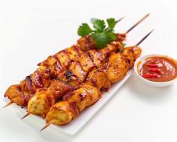 chicken satay skewers with sauce and garnish photo