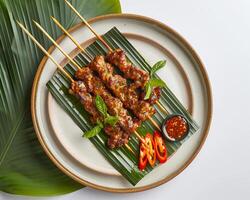a plate with skewers and sauce on it photo