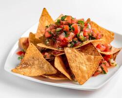 a plate of nachos with tomato salsa photo