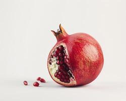 a pomegranate is cut in half and sitting on a white surface photo