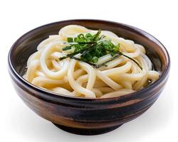 a bowl of noodles with green onions on a white background photo