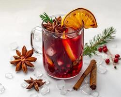 a glass of mulled wine with cinnamon, an orange and an anise photo