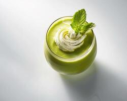 a green smoothie with whipped cream and mint leaves photo