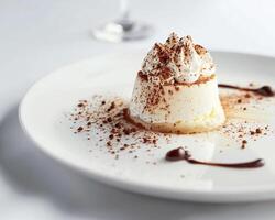a dessert on a white plate with a glass of wine photo