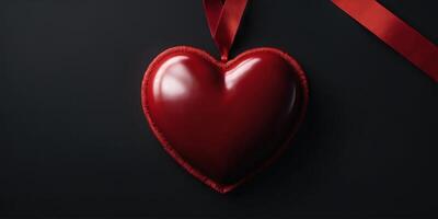 A bright red heart with a red ribbon on a black background with an empty space, banner. photo