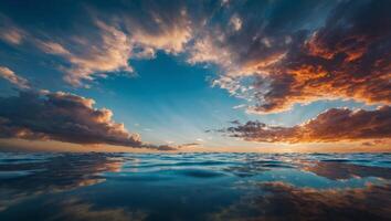 water expands to a large body, mirroring the colorful sky above Clouds scatter across it. photo