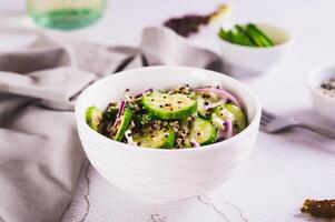 Vegetarian salad of quinoa, cucumber and red onion in a bowl on the table photo