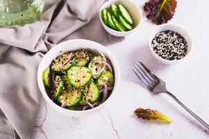 Healthy organic cucumber, quinoa and onion salad in a bowl on the table photo