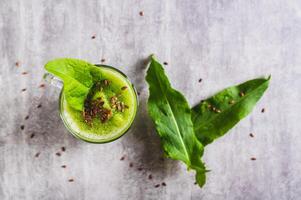 Close up of refreshing smoothie made from sorrel leaves and flax seeds in a glass top view photo