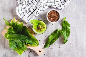 Refreshing smoothie made from sorrel leaves and flax seeds in a glass on the table top view photo