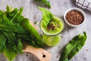 Detox smoothie made from green sorrel and flax seeds in a glass on the table photo