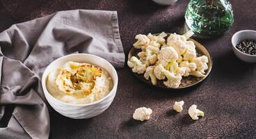 Homemade creamy cauliflower soup in a bowl on the table web banner photo