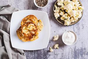 Spicy vegetarian cauliflower fritters on a plate on the table top view photo