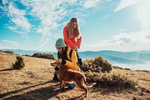 two friends are playing with a dog in nature photo