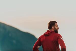 An athlete rests on top of a mountain after exhausting running training. photo