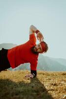 A man doing abs exercises on top of a mountain photo