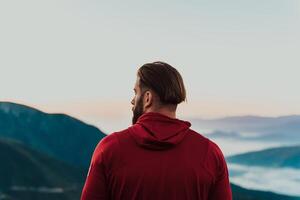 An athlete rests on top of a mountain after exhausting running training. photo