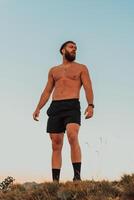 An athlete rests on top of a mountain after exhausting running training. photo
