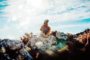 Cheering woman backpacker enjoy the view on sunrise mountain top cliff edge photo