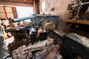 A senior man procesing wood on a lathe and making wooden dishes in the workshop photo
