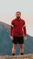 An athlete rests on top of a mountain after exhausting running training. photo