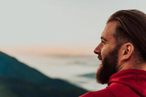 An athlete rests on top of a mountain after exhausting running training. photo