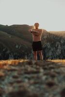 A man stretching his arms after a hard workout in the early hours of the morning photo