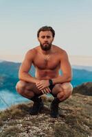 An athlete rests on top of a mountain after exhausting running training. photo