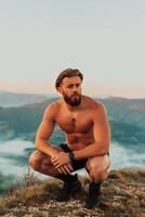 An athlete rests on top of a mountain after exhausting running training. photo