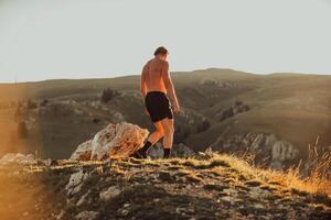 An athlete rests on top of a mountain after exhausting running training. photo