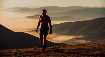 An athlete rests on top of a mountain after exhausting running training. photo