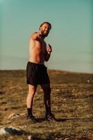 An athlete rests on top of a mountain after exhausting running training. photo