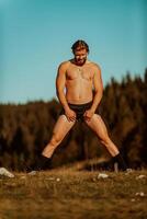 A man stretching after a hard workout in the early hours of the morning photo