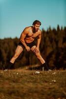 A man stretching after a hard workout in the early hours of the morning photo